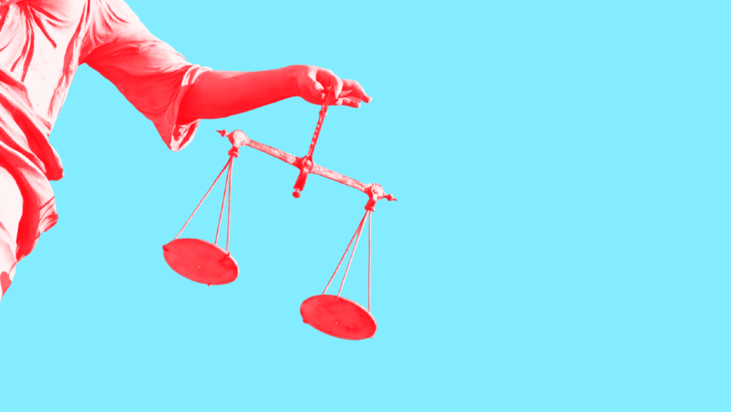 A red-tinted Lady Justice dangling unbalanced scales