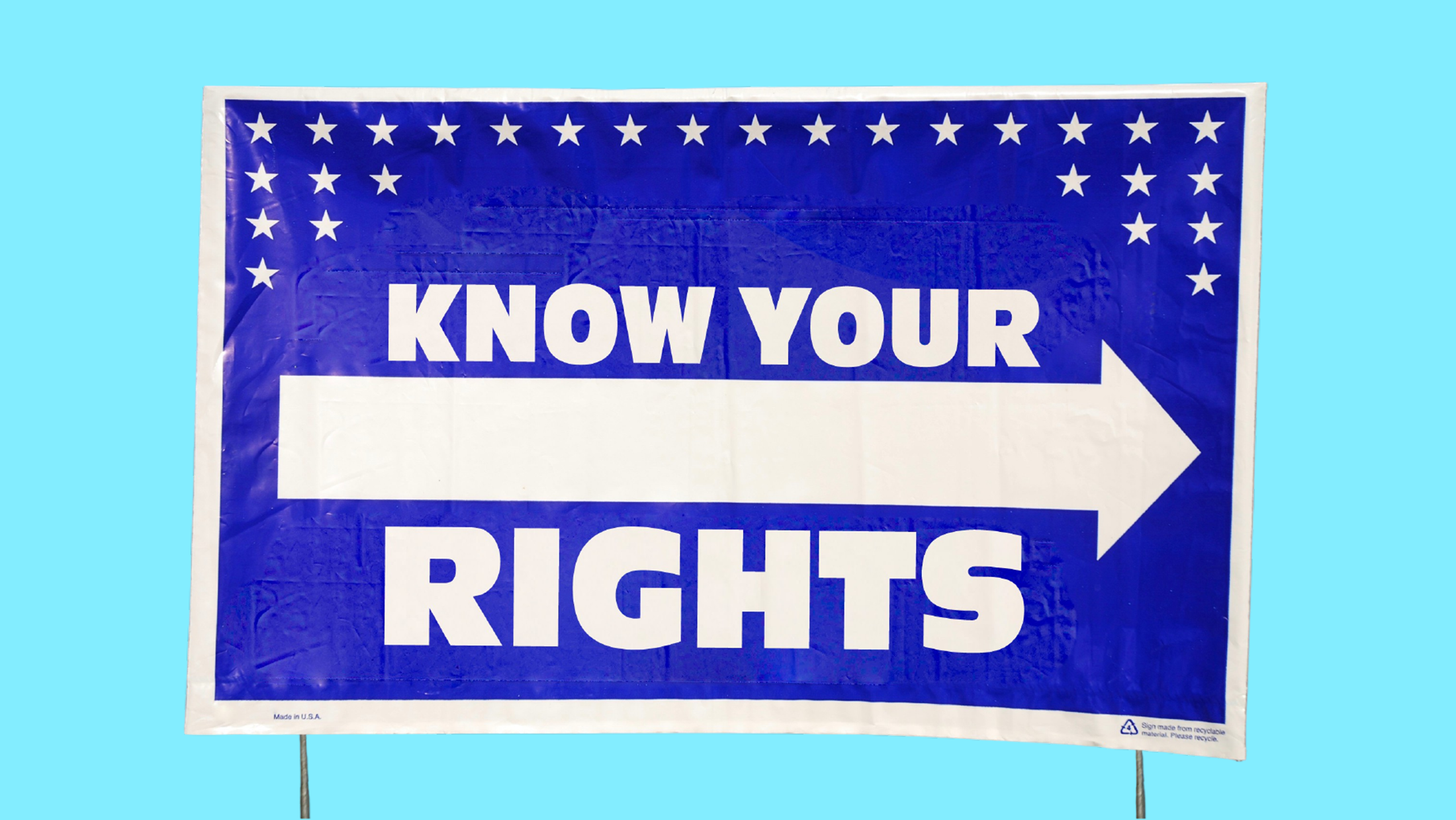 A blue yard sign with a right-pointing arrow and stars that says "KNOW YOUR RIGHTS"