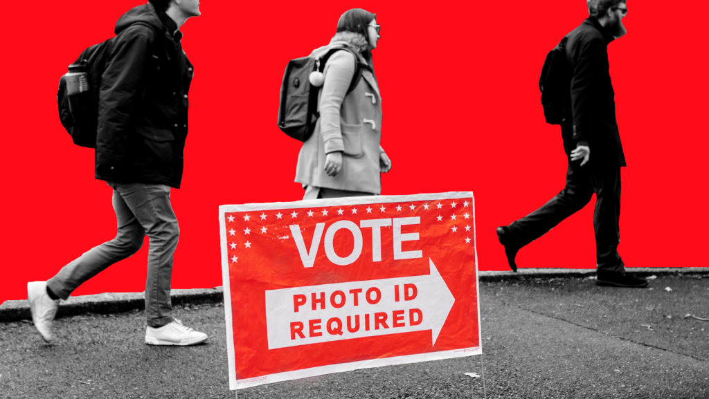 A red yard sign that says "VOTE PHOTO ID REQUIRED" with three students walking in the background