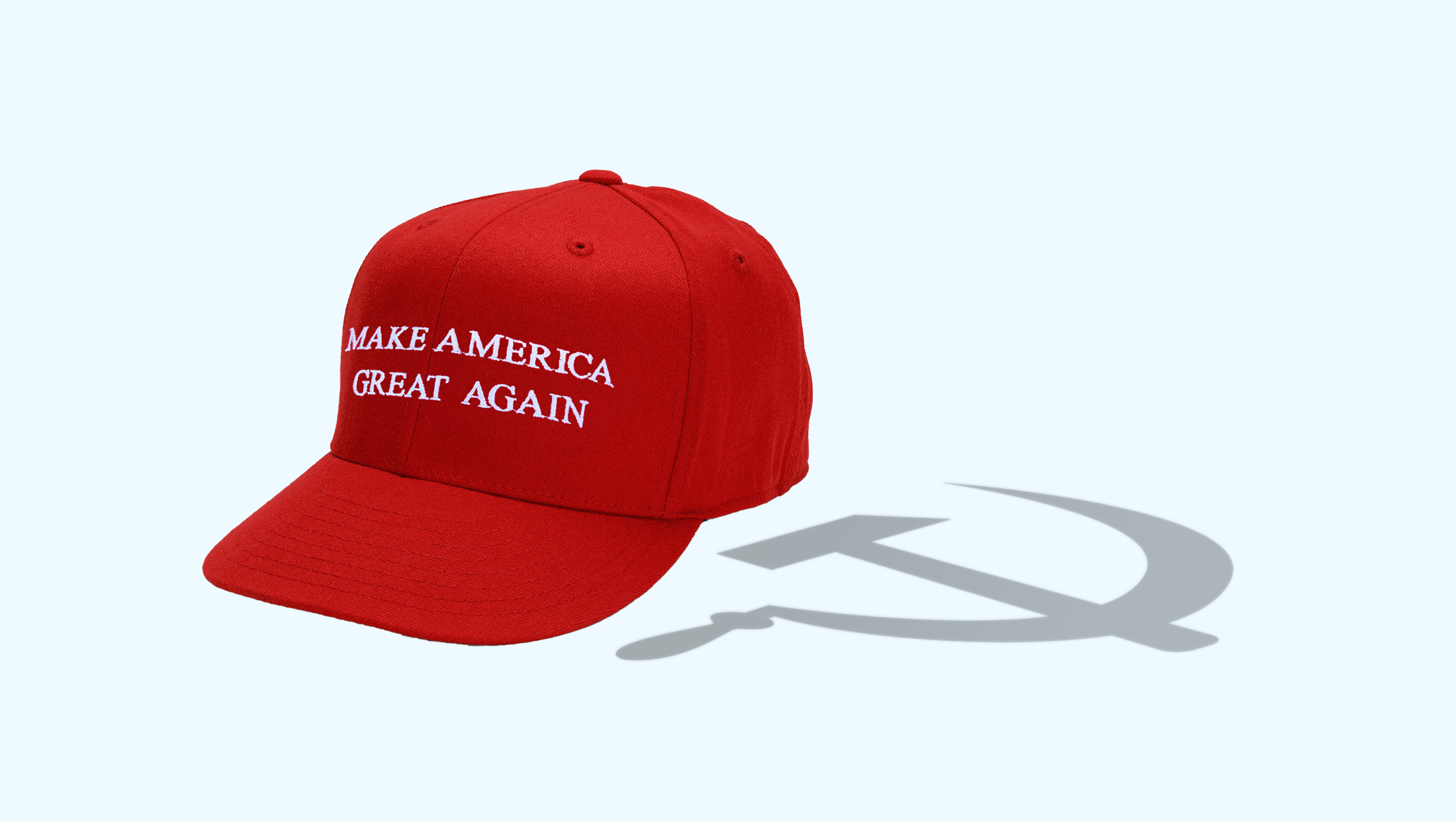 A red "MAKE AMERICA GREAT AGAIN" hat that is casting a shadow shaped like a communist hammer and sickle