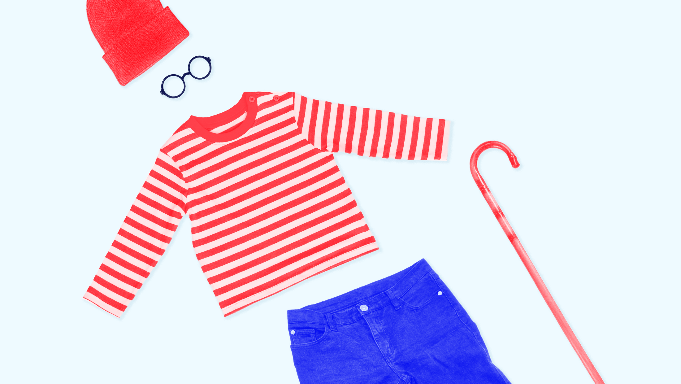 Light blue background with a red hat, black circular glasses, a red and white striped "Where's Waldo?" long sleeve shirt, a blue pair of pants, and a red cane all laid out separately.