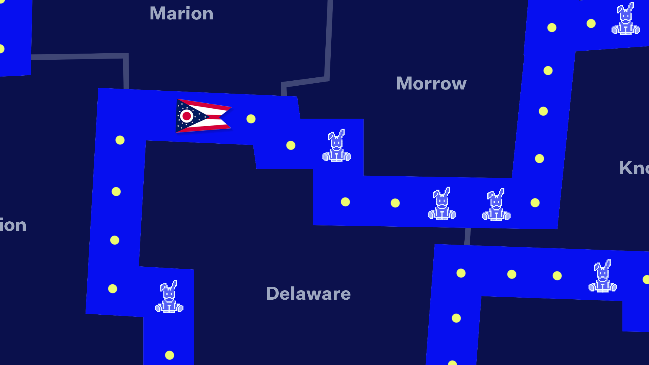 A dark-blue map of Ohio counties with a Pac-Man game superimposed on top, with Pac-Man replaced by the Ohio flag and the ghosts replaced by donkeys.