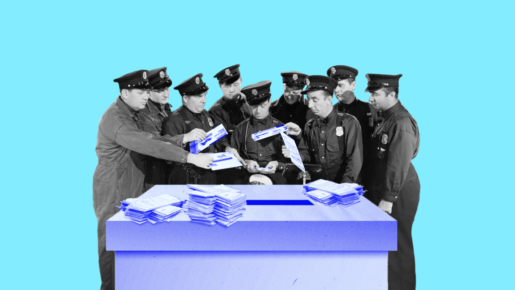 A group of police officers standing around a large, light blue ballot box scrutinizing voted ballots.