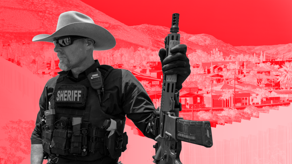 Red background with black and white toned image of Pinal County, Arizona Sheriff Mark Lamb in his uniform and holding a gun in front of a backdrop of the U.S.-Mexico border.