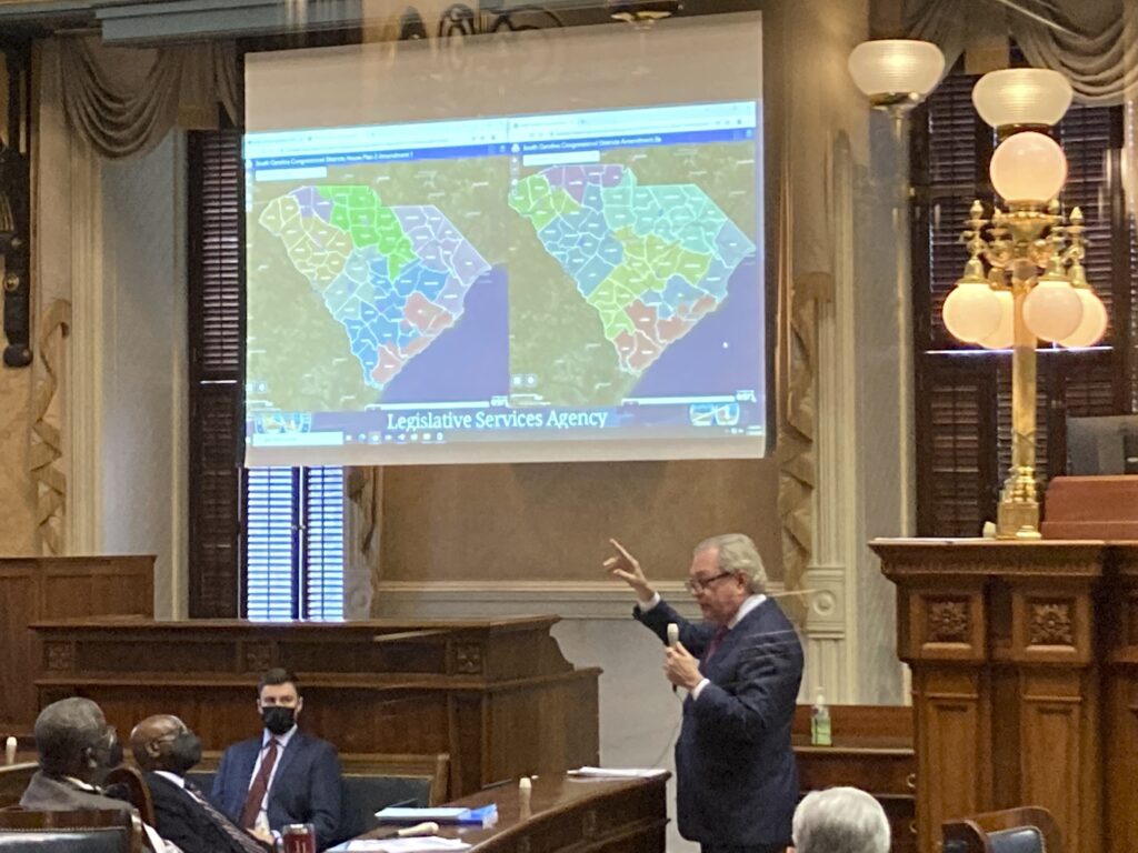 State Sen. Dick Harpootlian, D-Columbia, compares his proposed map of U.S. House districts drawn with 2020 U.S. Census data to a plan supported by Republicans on Jan. 20, 2022, in Columbia, S.C. Federal judges are deciding whether South Carolina's new congressional maps are legal in a lawsuit by the NAACP which says the districts dilute Black voting power. (AP Photo/Jeffrey Collins)