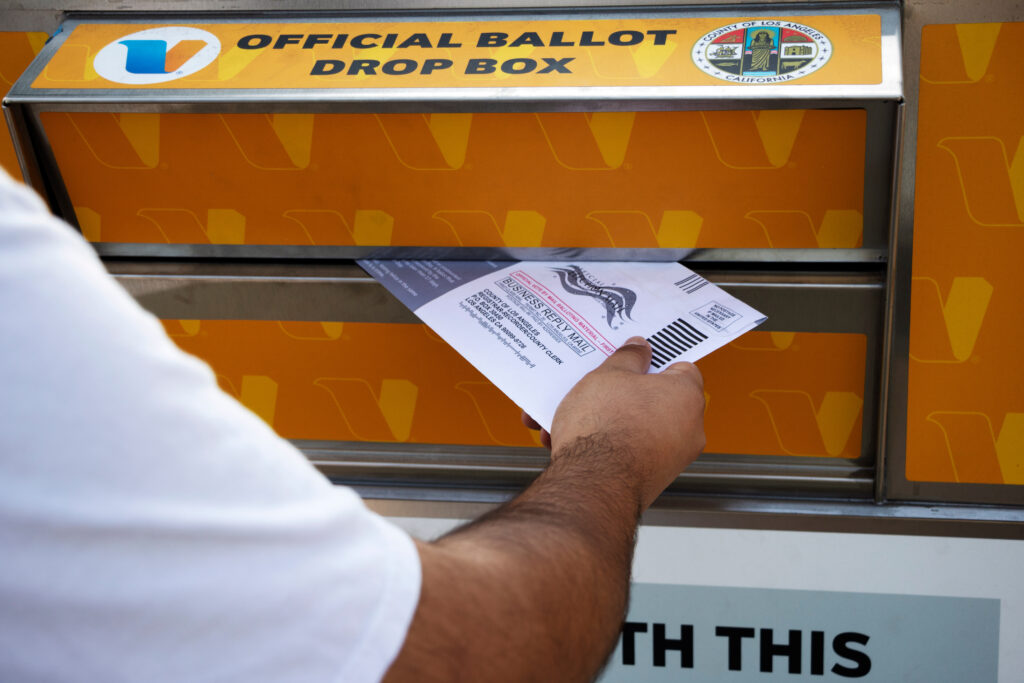 Hand inserting mail voting ballot into an official county drop box on October 17, 2020 in Los Angeles, California. (Adobe Stock)