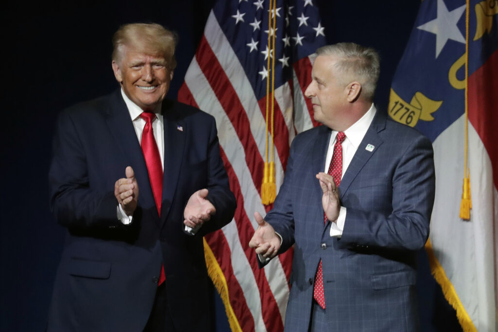 Former President Donald Trump, left, is welcomed by Michael Whatley, Chairman of the N.C. GOP, before he speaks at the North Carolina Republican Convention Saturday, June 5, 2021, in Greenville, N.C. (AP Photo/Chris Seward)