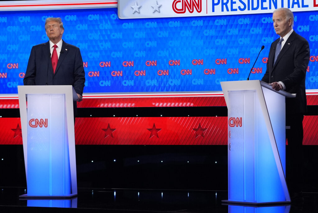 Donald Trump and Joe Biden stand at CNN labeled podiums.
