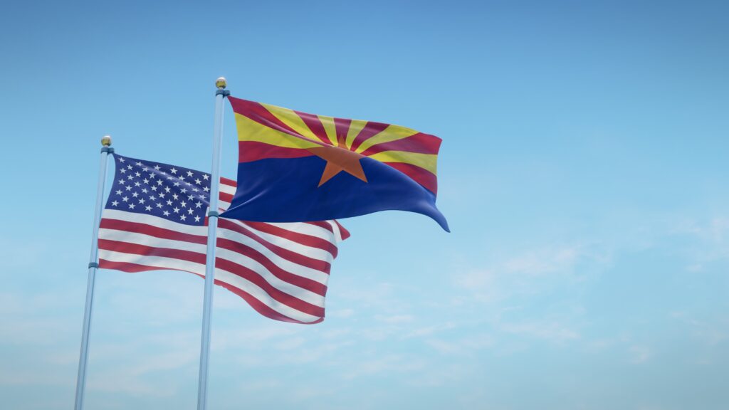 Waving flags of the USA and the US state of Arizona against blue sky backdrop. 3d rendering (Adobe Stock)