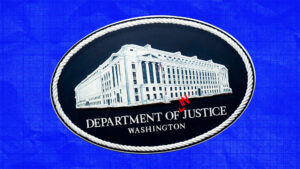 Department of Justice logo, red "IN" with carrot, with blue background