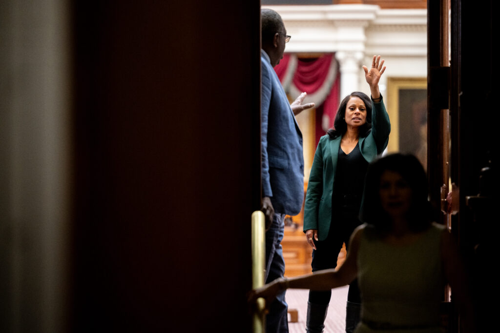 Democratic Texas Rep. Nicole Collier gestures from the House floor in the State Capitol on August 19, 2025 in Austin, Texas. Collier spent the night on the House floor after refusing a mandatory escort by Department of Public Safety. Collier is one of dozens of Democratic lawmakers who fled the state earlier this month after a two-week standoff with Republicans over their newly introduced plan to redraw Texas' congressional maps