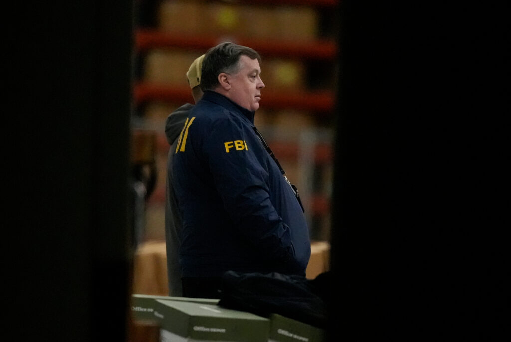 An FBI employee stands inside a Fulton County election facility during an FBI raid in January 2026, in Union City, Georgia, near Atlanta. (AP Photo: Mike Stewart)