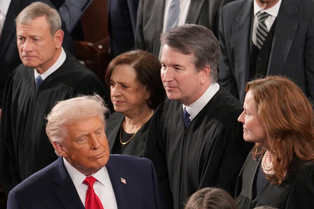 President Donald Trump walks by Chief Justice John Roberts, Justice Elena Kagan, Justice Brett Kavanaugh and Justice Amy Coney Barrett, as he arrives on the House floor to give his State of the Union address, Feb. 24, 2026. (AP Photo/J. Scott Applewhite)