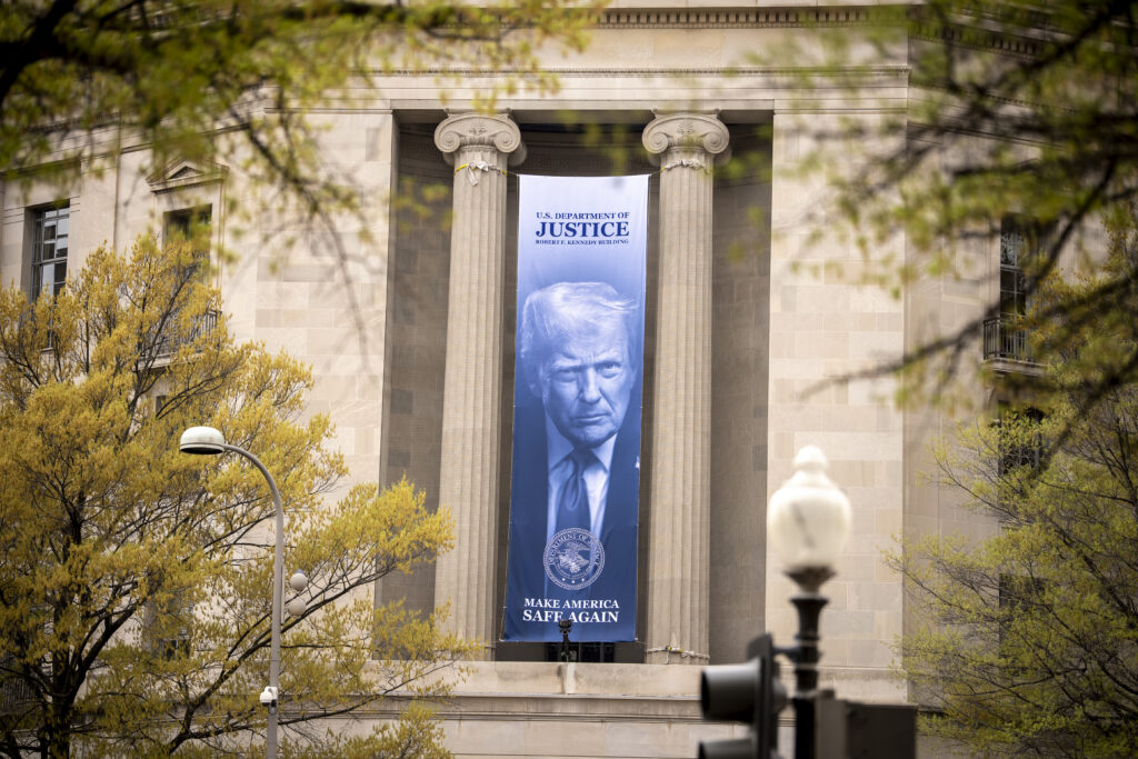 A large image of President Trump hanging from Justice Department headquarters on April 3, 2026 in Washington, D.C.