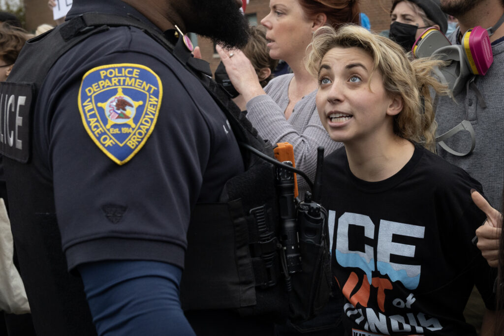 Then-congressional candidate Kat Abughazaleh in front of a Broadview, Illinois, police officer near an Immigration and Customs Enforcement facility on Oct. 17. (Photo: Scott Olson/Getty Images)