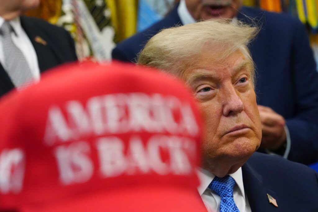 A red cap stating "America Is Back" sits next to President Donald Trump in the Oval Office of the White House, Friday, June 26, 2026, in Washington. (AP Photo/Julia Demaree Nikhinson)